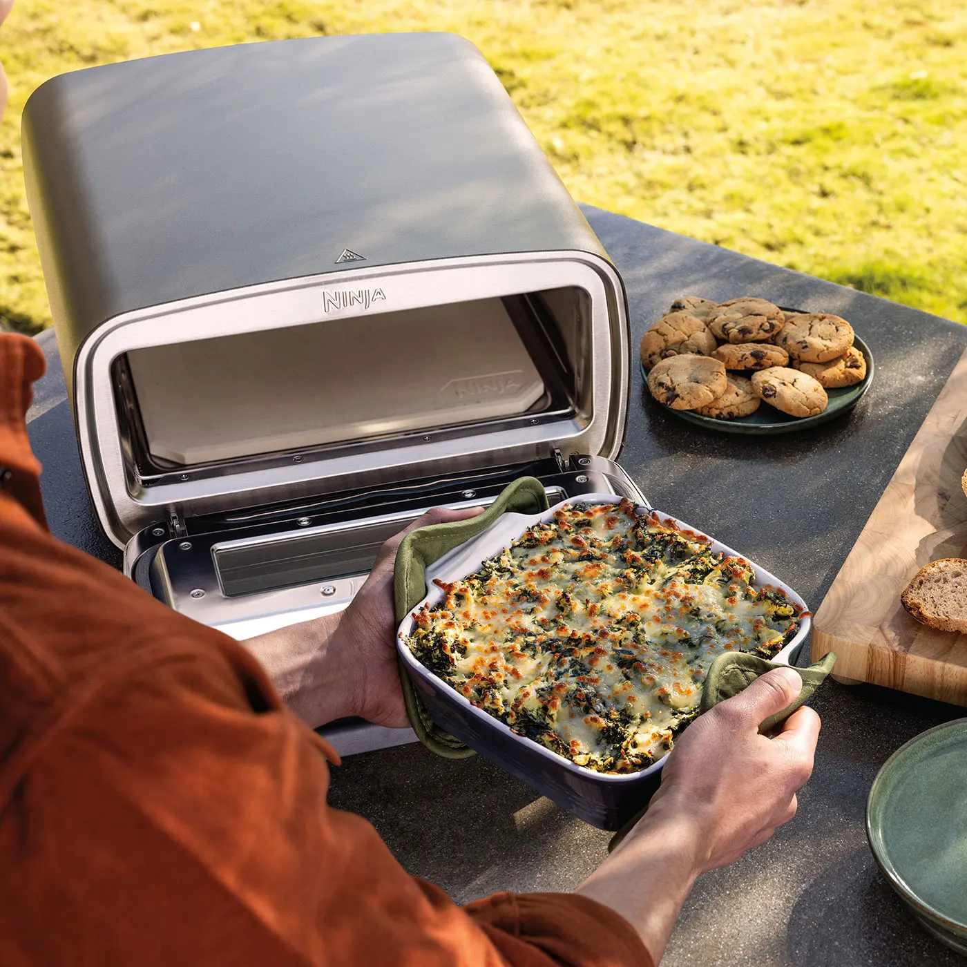 Ninja MO201UK InUse BackYard OnCounter RemovingFood Man